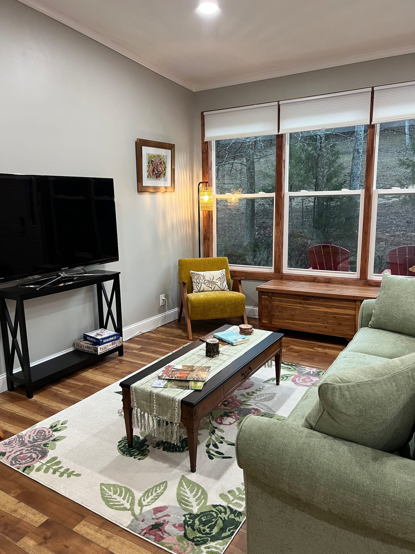 Living room with queen sleeper sofa and large windows facing the stream